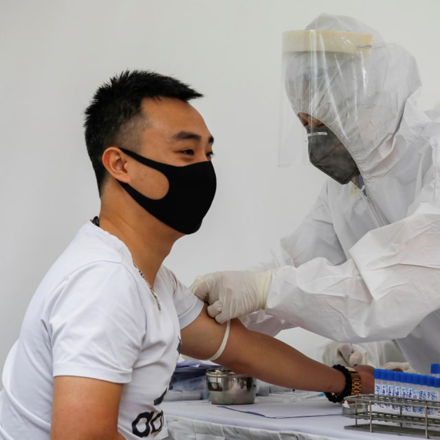 Petugas kesehatan mengambil sampel darah seorang ODP untuk dites virus corona, di Hanoi, Vietnam. Foto: REUTERS/Kham