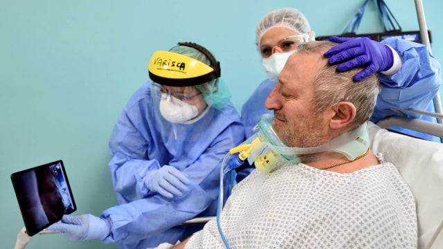Tim medis Rumah Sakit Cernusco sul Naviglio di Milan, Italia membantu pasien corona saat video call dengan kerabat. Foto: REUTERS/Flavio Lo Scalzo