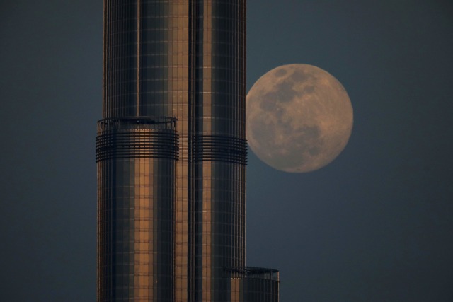 Supermoon pink di belakang Burj Khalifa di Dubai, Uni Emirat Arab Senin (7/4). Foto: REUTERS/Christopher Pike