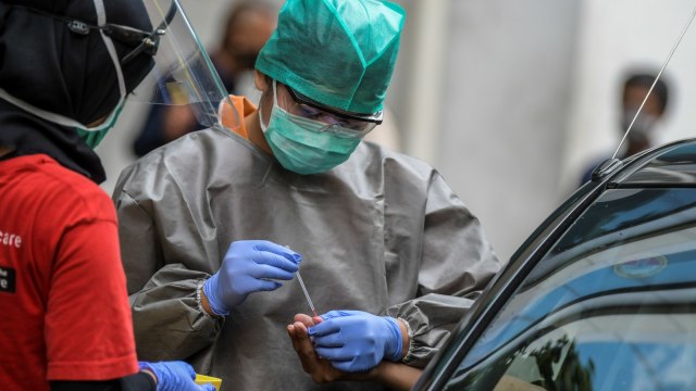 Petugas medis mengambil sampel darah jurnalis saat Rapid Test COVID-19 secara Drive-Thru di Halaman Gedung Kementerian Kominfo, Jakarta, Rabu (8/4). Foto: ANTARA FOTO/Galih Pradipta