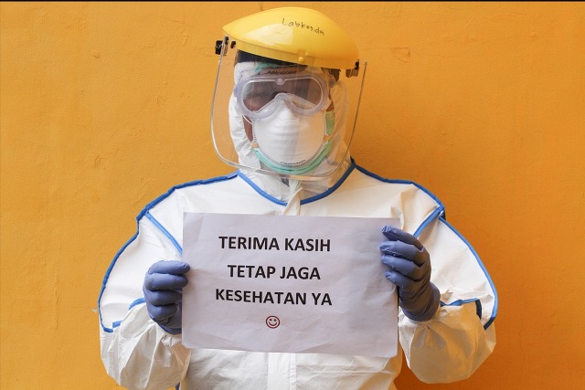 Petugas medis menunjukkan imbauan untuk masyarakat terkait virus corona seusai melaksanakan SWAB Test di Cimanggis, Depok, Jawa Barat, Minggu (8/4). Foto: ANTARA FOTO/Asprilla Dwi Adha