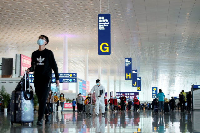 Penumpang menggunakan alat pelindung terlihat di Bandara Internasional Tianhe, Wuham Hubei, China, Rabu (8/4).  Foto: REUTERS / Aly Song