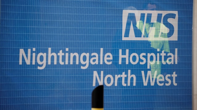 Dua orang petugas sedang berbincang diluar Rumah Sakit NHS Nightingale North West di Kota Manchester, Inggris (8/4). Foto: REUTERS/Phil Noble