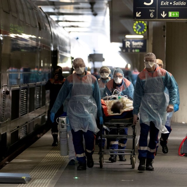 Tenaga medis mengevakuasi pasien positif Covid-19 memasuki gerbong kereta cepat TGV di Stasiun Gare d Austerlitz, Paris, Prancis. Foto: Thomas Samson/Pool via REUTERS