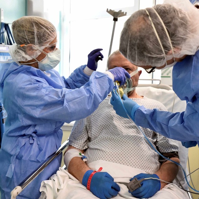 Tim medis membantu melepas alat pernafasan pasien corona sebelum video call dengan kerabat.
 Foto: REUTERS/Flavio Lo Scalzo