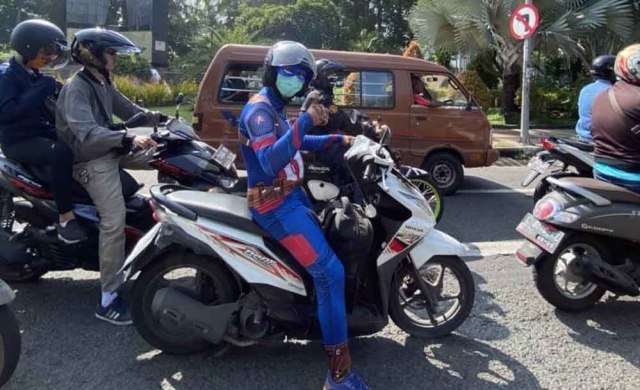 Aksi pengendara motor menggunakan pakaian superhero