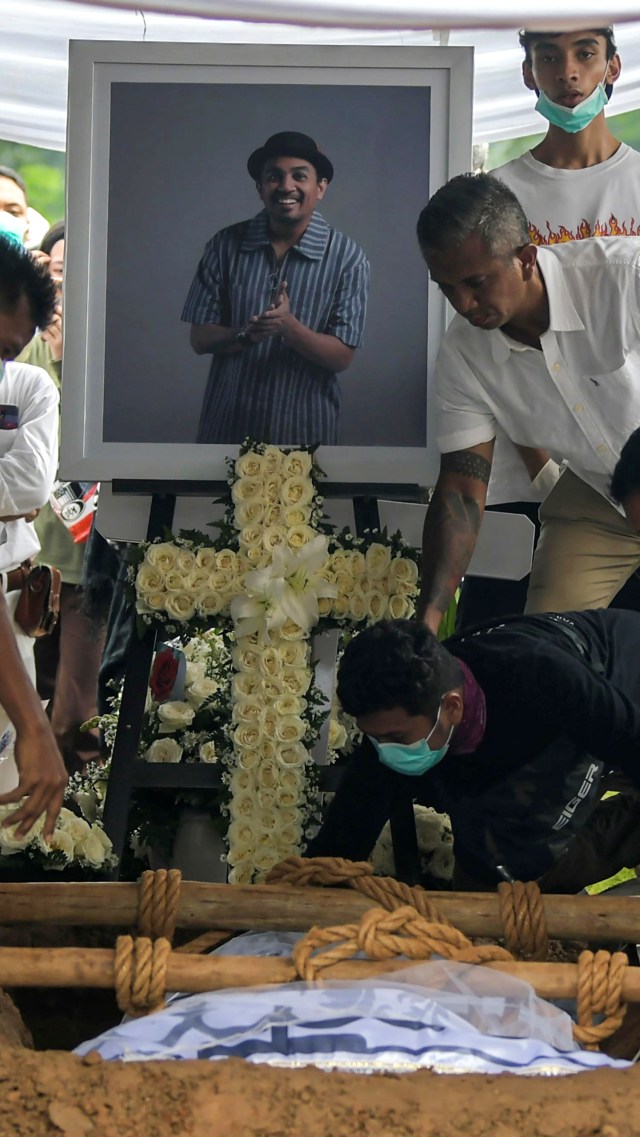Jenazah Glenn Fredly saat diturunkan ke liang lahat di TPU Tanah Kusir, Jakarta, Kamis (9/4/2020). Foto: ANTARA FOTO/Galih Pradipta