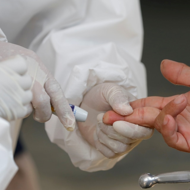 Petugas kesehatan mengambil sampel darah seorang warga untuk tes corona. Foto: REUTERS/Willy Kurniawan