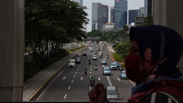 Warga mengenakan masker saat melintas di JPO Dukuh Atas, Jalan Jenderal Sudirman, Jakarta. Foto: ANTARA FOTO/Indrianto Eko Suwarso