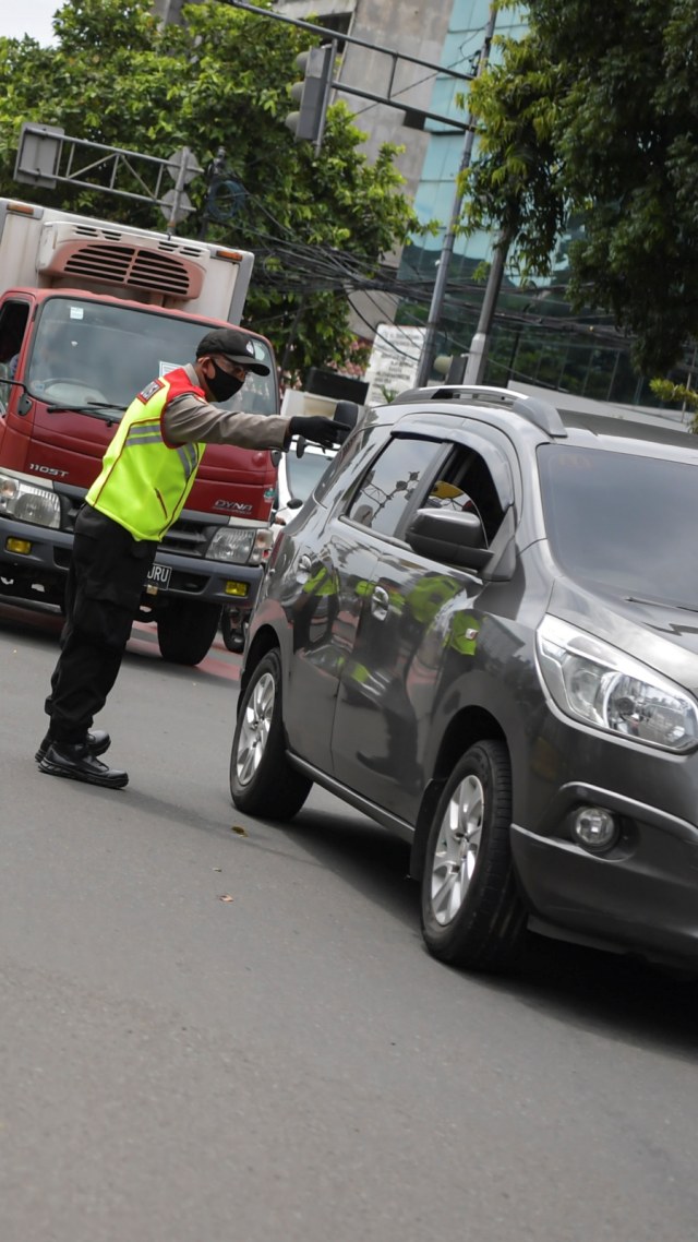 Polisi melakukan imbauan kepada pengendara mobil untuk dapat mematuhi penerapan Pembatasan Sosial Berskala Besar (PSBB) di kawasan Menteng, Jakarta (11/4). Foto: ANTARA FOTO/Nova Wahyudi