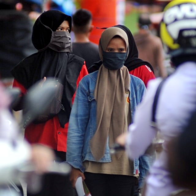Warga menggunakan masker saat berbelanja di Pasar Raya Padang, Sumatera Barat, Senin (6/4). Foto: ANTARA FOTO/Iggoy el Fitra