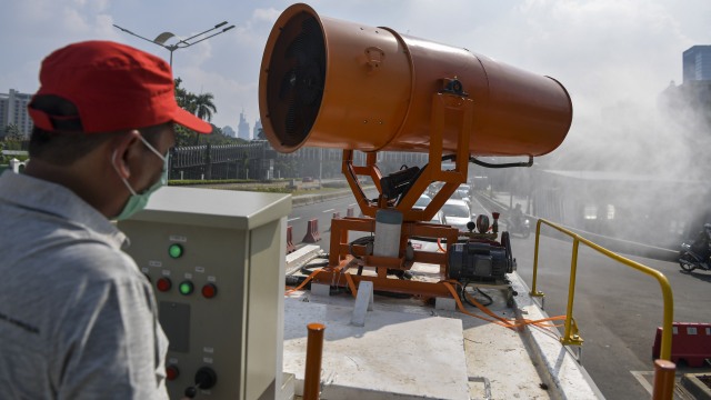 Petugas gabungan dari TNI dan PMI melakukan penyemprotan cairan disinfektan menggunakan mobil gunners spraying di Jakarta. Foto: ANTARA/Nova Wahyudi