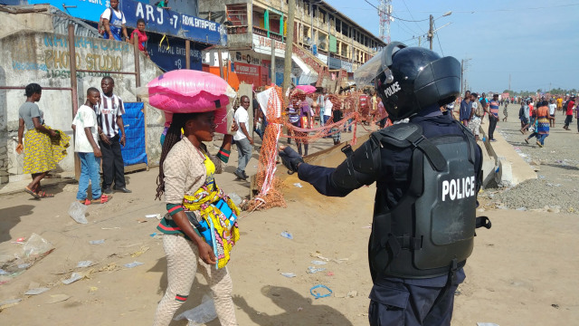 Polisi mengejar pembeli di pasar Lampu Merah pada hari pertama penerapan lockdown di Monrovia, Liberia. Foto: REUTERS / Derick Snyder