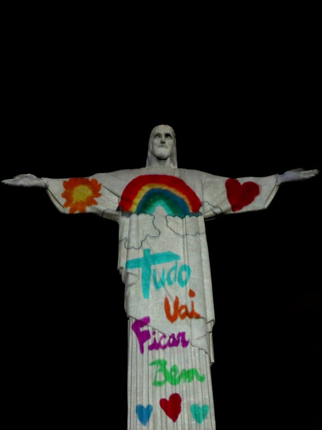 Patung Christ the Redeemer menyala dengan warna pelangi dan bertuliskan 'Semuanya akan baik-baik saja' saat acara Minggu Paskah di Rio de Janeiro, Brasil. Foto: REUTERS / Ricardo Moraes