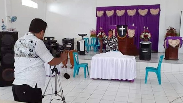 Pengelola BUMKam mengambil gambar pendeta membawakan Ibadah Paskah di dalam gereja yang disiarkan secara langsung melalui jaringan TV Kabel ke rumah-rumah warga