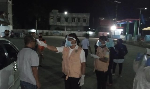 Pengguna jalan yang melewati pos perbatasan di kawasan Aceh Tamiang diperiksa suhu tubuh. Foto: Dok. Ditlantas Polda Aceh