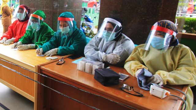 Tenaga medis menggunakan alat pelindung diiri saat melayani warga yang akan berobat di Pusat Kesehatan Masyarakat (Puskesmas) Dumai Kota di Dumai, Riau. Foto:  ANTARA FOTO/Aswaddy Hamid