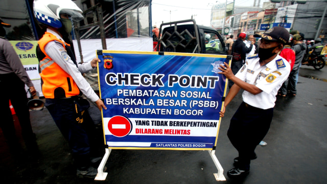 Petugas Dishub Kabupaten Bogor mempersiapkan spanduk dan rambu-rambu jalan jelang PSBB. Foto: ANTARA/Yulius Satria Wijaya