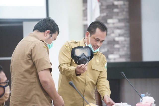 Kepala Dinas Kesehatan Aceh, dr Hanif saat menunjukkan APD dalam rapat bersama DPR Aceh. Dok. DPRA 