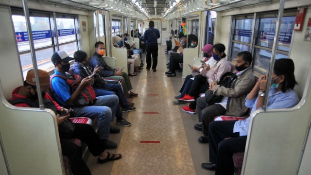 Sejumlah penumpang menggunakan masker dan duduk berjarak di dalam gerbong KRL Commuter Line, Stasiun Bogor, Jawa Barat. Foto: ANTARA FOTO/Arif Firmansyah