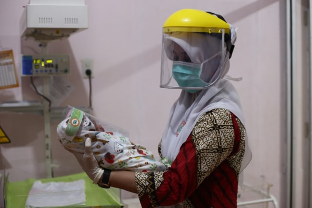 Perawat dan bayi baru lahir memakai face shield di RS Avicenna, Bireuen, Aceh. Foto: Amanda Jufrian untuk acehkini 