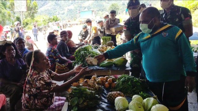 Wakil Bupati Tolikara, bersama TNI Polri membagikan makanan di pasar tradisional Tolikara.