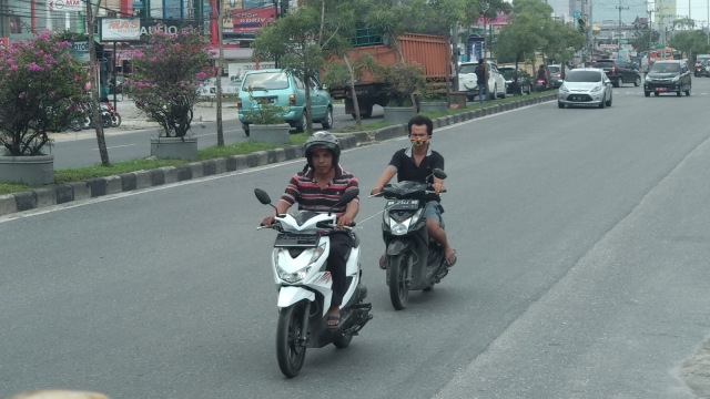PENGENDARA sepeda motor dan mobil di Jalan HR Soebrantas, Pekanbaru, masih ramai seperti hari-hari biasanya sebelum pemberlakuan PSBB, Jumat, 17 April 2020. Masih banyak pengendara tak mengenakan masker.   