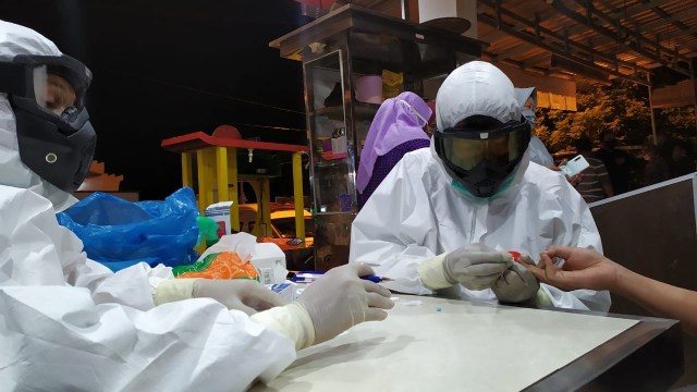 Petugas medis saat melakukan rapid test pada sebuah warung kopi di Aceh, Sabtu (18/4) malam. Foto: Zuhri Noviandi/kumparan