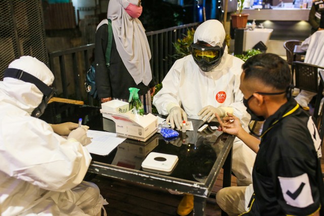 Pemeriksaan rapid test COVID-19 yang dilakukan di warung kopi di Kota Banda Aceh, Aceh, Sabtu (18/4) malam. Foto: Abdul Hadi/acehkini