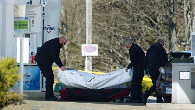 Pekerja  medis mengeluarkan mayat dari sebuah pompa bensin di Enfield, Nova Scotia, Minggu, (19/4). Foto: The Canadian Press via AP/Andrew Vaughan