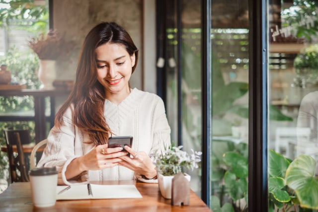 Perempuan sedang belanja online lewat ponsel. Foto: Shutterstock