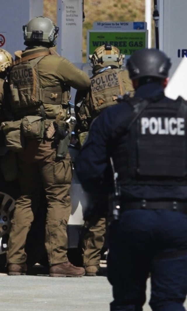 Petugas Polisi Mounted Royal Kanada mengelilingi seorang tersangka di sebuah pompa bensin di Enfield, Nova Scotia. Foto: The Canadian Press via AP/Tim Krochak