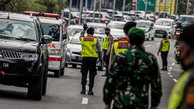 Petugas gabungan mengatur lalu lintas kendaraan dari luar kota saat penerapan Pembatasan Sosial Berskala Besar (PSBB) di Pasteur, Bandung, Jawa Barat, Foto: Antara/Agung Rajasa
