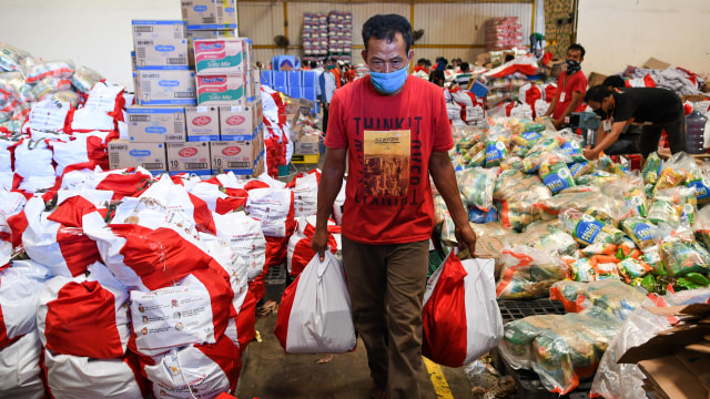 Pekerja mengemas paket bantuan sosial (bansos) di Gudang Food Station Cipinang, Jakarta, Rabu (22/4/2020). Foto: ANTARA FOTO/M Risyal Hidayat