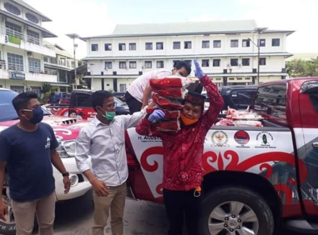Anggota DPR RI Agustiar Sabran saat memanggul beras untuk dibagikan kepada para mahasiswa di salah satu Universitas di Kota Palangka Raya, Kalteng. 