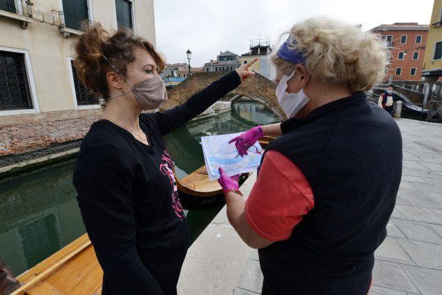 Anggota dari Row Venice sebelum mengirimkan makanan menggunakan gondola yang melintasi kanal Venesia, Italia.  Foto: AFP/ANDREA PATTARO