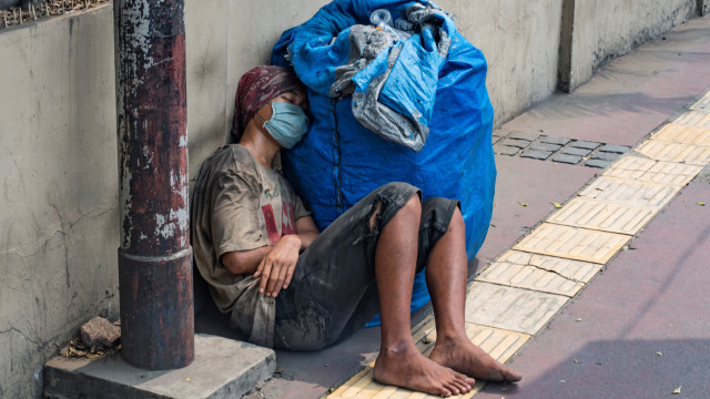 Seorang lelaki tidur siang di trotoar di pusat kota Jakarta. Foto: AFP/BAY ISMOYO 