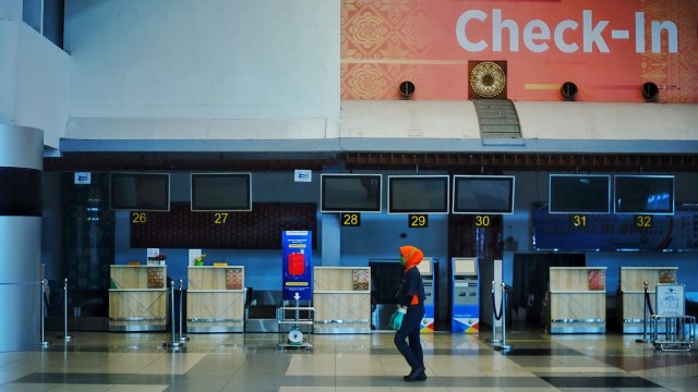 Seorang pegawai yang melintas di depan sejumlah counter chek in di Bandara Sultan Mahmud Baddarudin II Palembang, Sabtu (25/4) Foto: ary priyanto/Urban id