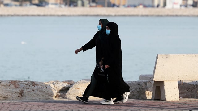 Dua orang wanita yang menggunakan masker berjalan di Qatif, Arab Saudi. Foto: REUTERS/Stringer