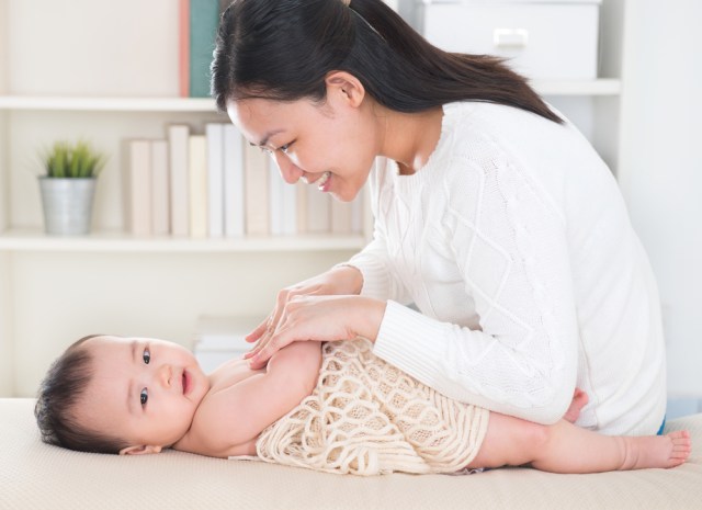 com-Ilustrasi ibu sedang memijat bayi menggunakan minyak telon atau minyak kayu putih.  Foto: Shutterstock