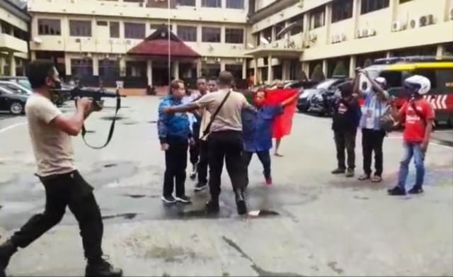 Tangkapan layar video viral tiga pemuda menerobos masuk ke Mapolda Maluku dan membentangkan bendera RMS. Foto: Istimewa