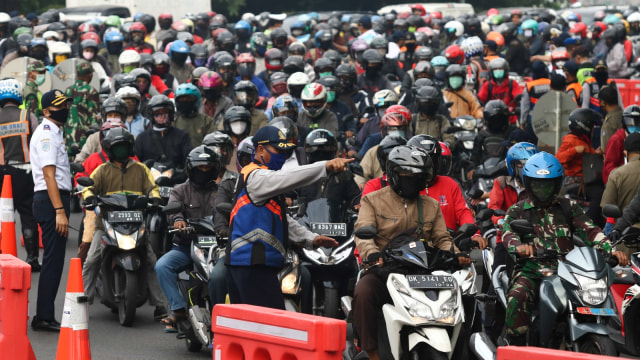 Petugas memeriksa dokumen kependudukan warga yang akan masuk ke Surabaya di Bundaran Waru, Surabaya, Jawa Timur, Selasa (28/4). Foto: ANTARA FOTO/Didik Suhartono