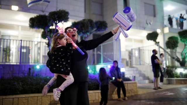 Warga Israel merayakan di jalan sekitar rumah mereka pada malam pembukaan Hari Kemerdekaan Israel yang ke-72 di Ashkelon, Israel, Selasa (28/4). Foto: REUTERS/Amir Cohen