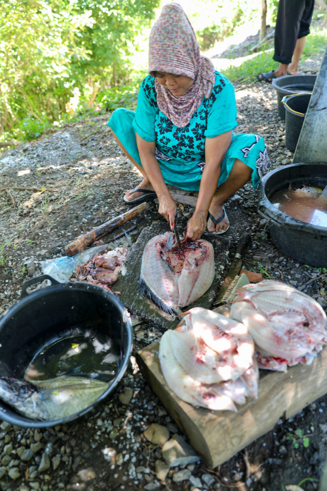 Nurul sedang membersihkan ikan untuk membuat ikan asin. Foto: Suparta/acehkini 