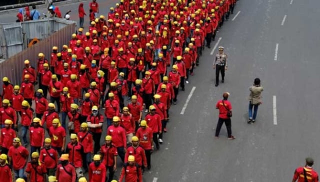 Polisi berjalan di samping sekelompok buruh yang berbaris untuk memperingati May Day di Jakarta, Indonesia, 1 Mei 2017. REUTERS / Beawiharta