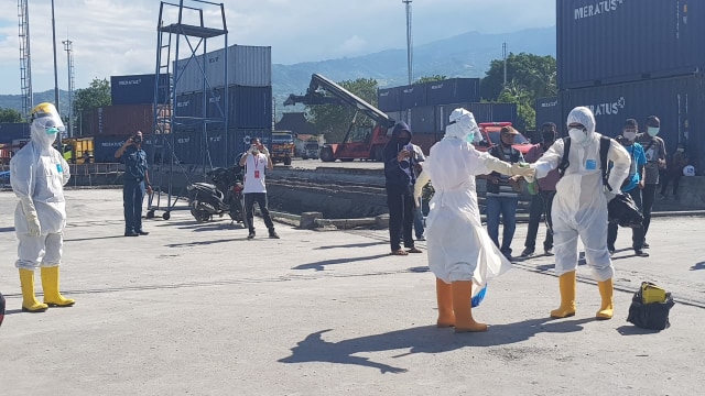 Tim medis dari Gugus Tugas COVID-19 Kabupaten Sikka disemprot disinfektan usai melakukan pemeriksaan terhadap awak kapal KM Meratus Bontang, Kamis (30/4/2020) siang. Foto: Mario WP Sina. 