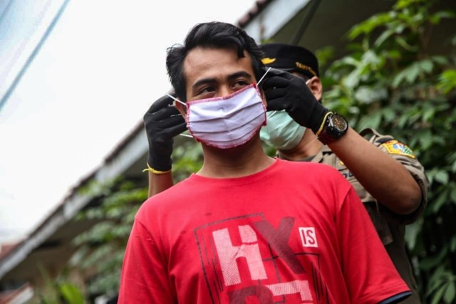 Petugas memasangkan masker gratis dari Pemprov DKI Jakarta. Foto: Dok. Pemprov DKI Jakarta