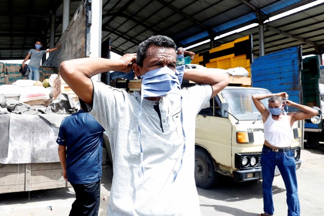 Para buruh bongkar muat memakai masker bantuan Pemerintah Kota Banda Aceh di terminal barang Santan, Aceh Besar, Aceh, Jumat (1/5). Foto: ANTARA FOTO/Irwansyah Putra