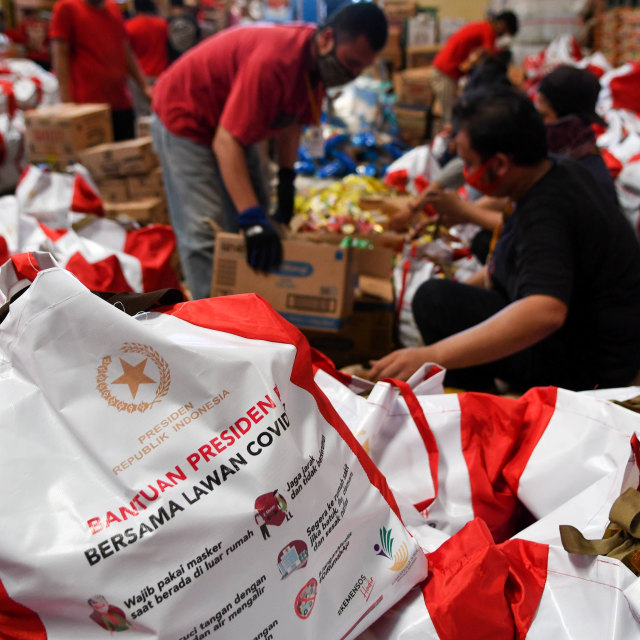 Pekerja mengemas paket bantuan sosial (bansos) di Gudang Food Station Cipinang, Jakarta. Foto: ANTARA FOTO/M Risyal Hidayat