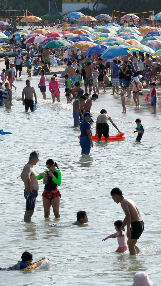 Warga beraktifitas di pantai, Minggu (3/5). Foto: REUTERS/Tyrone Siu